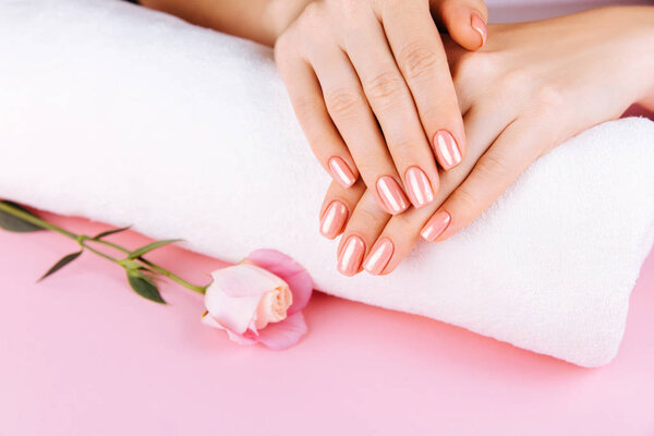 Beautiful Woman Hands with fresh eustoma. Spa and Manicure concept. Female hands with pink manicure. Soft skin skincare concept. Beauty nails. Over beige background