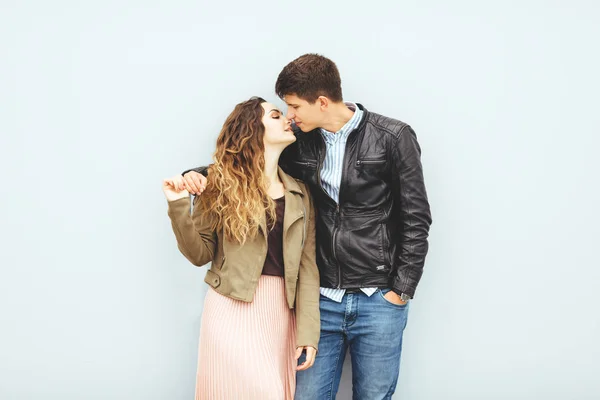 Gelukkig liefdevol paar geïsoleerd op grijze achtergrond. stijlvol beeld, goed humeur, verliefd kussen. — Stockfoto
