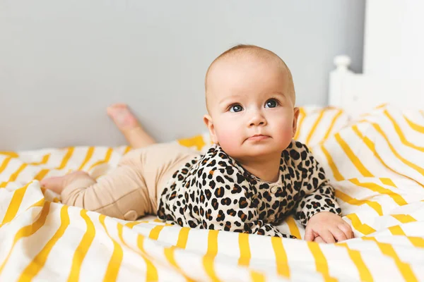 Bebê feliz com sorriso bonito sentado em um berço. Criança sentada na cama. Infância feliz — Fotografia de Stock