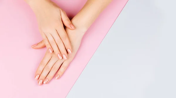 Bella donna Mani con eustoma fresco. Concetto Spa e Manicure. Mani femminili con manicure rosa. Morbido concetto di cura della pelle. Unghie di bellezza. Su sfondo beige — Foto Stock