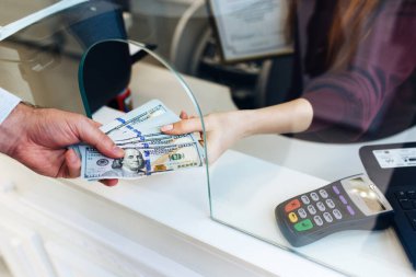 man changes money in a currency exchange, a large sum of dollars, an increase in the exchange rate, close up a money changing hands of people