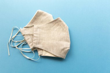 Mavi arka planda beyaz ev yapımı maske. Pek çok kullanım için. Kirliliğe, virüse, gribe ve koronavirüse karşı yüz maskesi koruması. Sağlık ve Cerrahi Konsept