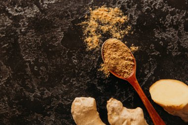 Taze zencefil kökü ve kuru zencefilli kaşık, köhne ahşap arka planda..