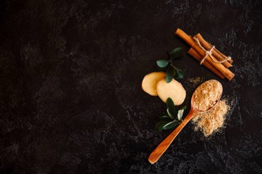 Koyu masada bal ve baharat, arkada kuru takvim, limon ve harç..