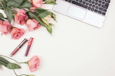 Dekoratif kadın kozmetik ürünleri ve östoma çiçekli mücevherler çerçevesi. Beyaz arkaplanda düz çiçek aranjmanı