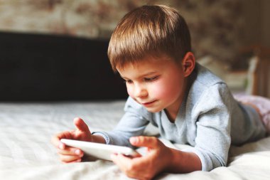Evde akıllı telefondan oyun oynayan tatlı çocuk..