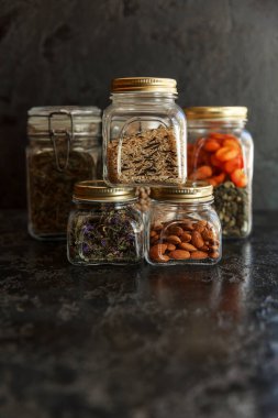 Yemek takımı. Çiğ tahıl, makarna, inleme, organik baklagiller ve cam kavanozlarda faydalı tohumlar..