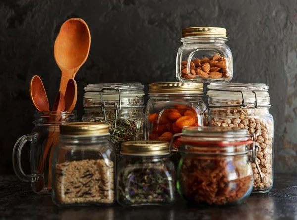 Jídlo. Surové obiloviny, těstoviny, krupice, organické luštěniny a užitečná semena ve skleněných nádobách. — Stock fotografie