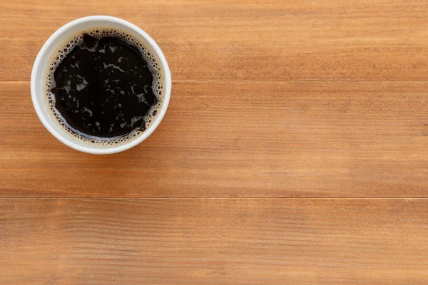 Cup of black coffee on wooden background with copy space — Stock Photo, Image