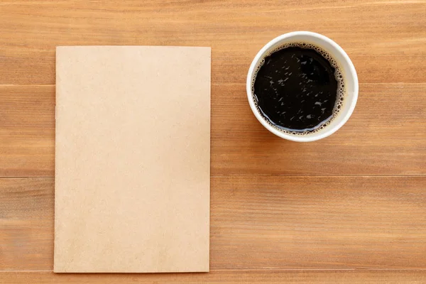 Libro de tapa en blanco y taza de café sobre fondo de madera marrón — Foto de Stock