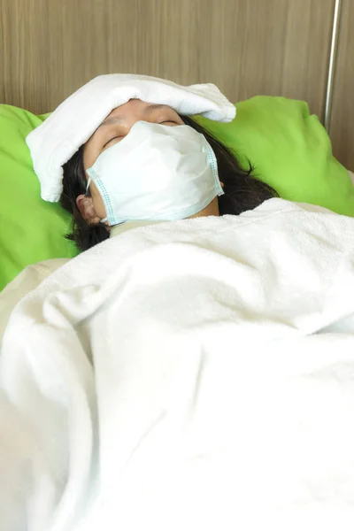 sick woman in protective medical mask and cover with blanket sle