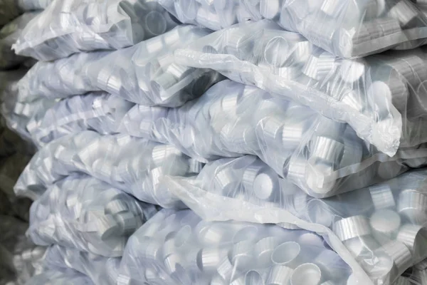 Gray plastic bottle caps in plastic bag — Stock Photo, Image