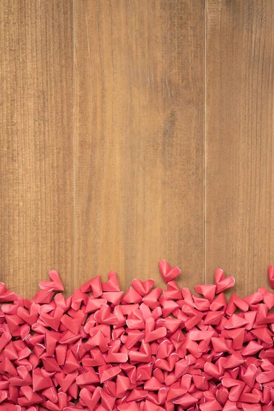 Många röda små Pappershjärtan formade på trä bakgrund — Stockfoto