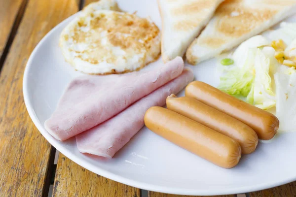 Frühstück - Wurst, Schinken, Spiegelei, Brot auf weißem Teller — Stockfoto