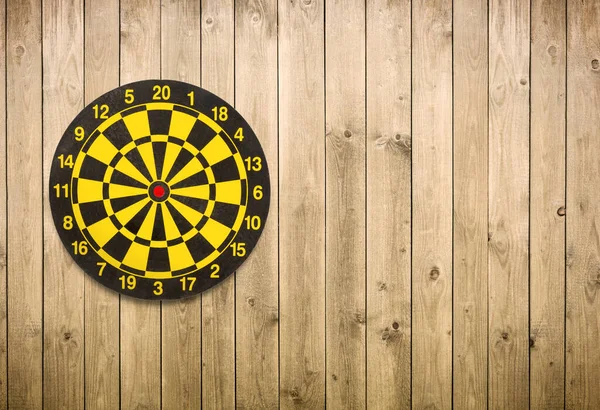 Dartboard no fundo da parede da prancha de madeira marrom com espaço de cópia — Fotografia de Stock