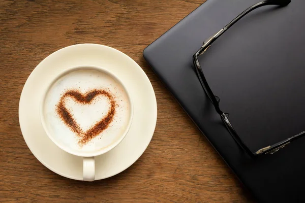 Cup of cappuccino coffee with  heart shaped chocolate powder — Stock Photo, Image