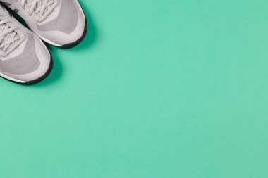 Turkuaz arka planda gri spor ayakkabılar. Sağlıklı yaşam tarzı ve günlük eğitim kavramı.  