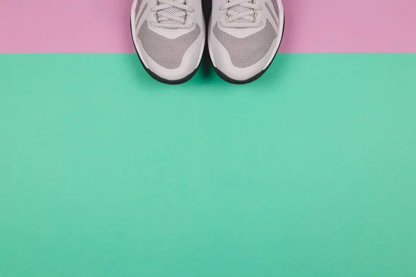 Grå sneakers på turkos och violett bakgrund. Begreppet hälsosam livsstil och vardagsträning. — Stockfoto