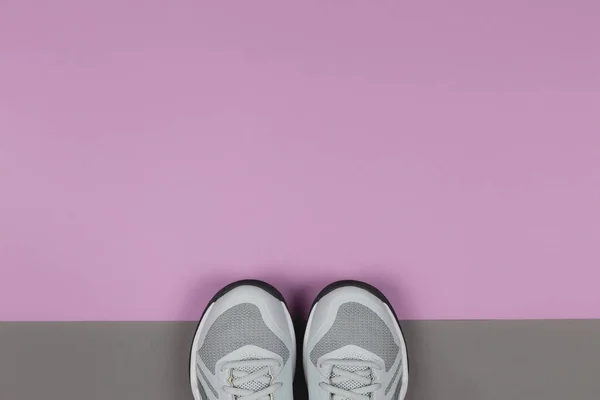 Zapatillas grises sobre fondo violeta y gris. Concepto para un estilo de vida saludable y entrenamiento diario . — Foto de Stock