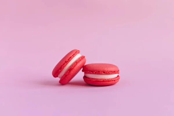 Két ízletes francia macaron rózsaszín háttérrel. — Stock Fotó