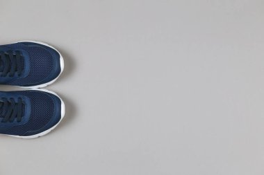 Gri arka planda klasik mavi spor ayakkabılar. Sağlıklı yaşam tarzı ve günlük eğitim kavramı.