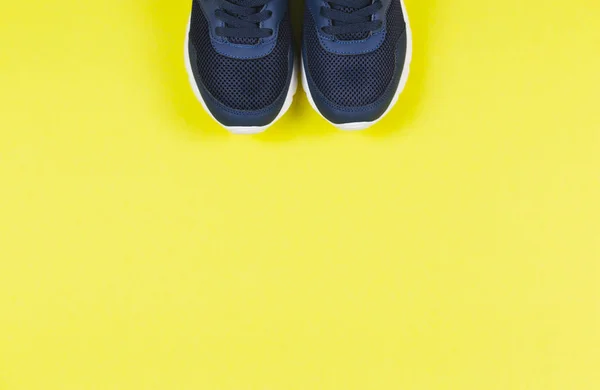 Klassische blaue Turnschuhe auf gelbem Hintergrund. Konzept für gesunden Lebensstil und tägliches Training. — Stockfoto