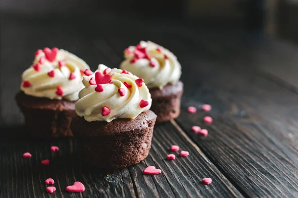 Cupcakes Valentine, decorados com corações doces na mesa de madeira escura . — Fotografia de Stock