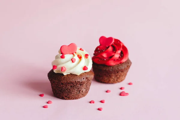 Magdalenas de San Valentín, decoradas con corazones dulces sobre fondo rosa pastel . — Foto de Stock