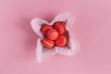 Pembe arka plandaki bir kutuda kırmızı Fransız kurabiyeleri. Sevgililer Günü için kavram. 