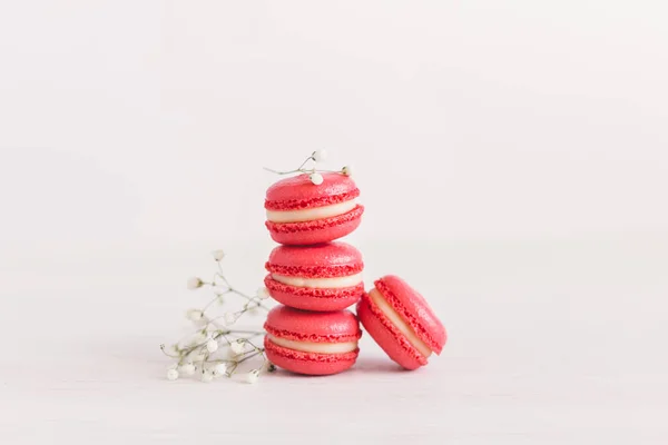 Tasty french macaroons with small flowers on a white background. — Stock Photo, Image