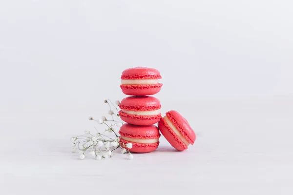 Macarons français savoureux avec de petites fleurs sur un fond blanc . — Photo