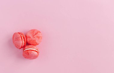 Tasty french macarons on a pink background.  Flat lay.  Place for text.