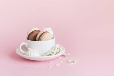 Fransız badem kurabiyesi, marşmelov ve pembe pastel arka planda bahar çiçeği. Romantik bahar arkaplanı.