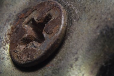 Kapı kolunda eski, tozlu ve paslı bir vida var.