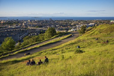 Edinburgh, İskoçya / Uk, 21 Haziran 2019: Piknikçiler İskoçya 'nın Edinburgh kentindeki Unesco Dünya Mirası Alanı Calton Hill' den gün batımını izliyorlar.