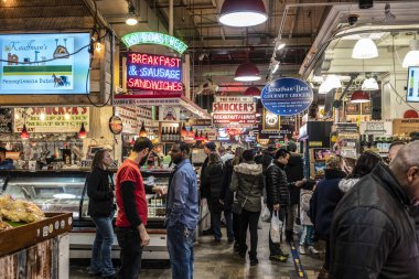 Philadelphia, PA/USA-Feb 29, 2020: Patrons shop at the Reading Terminal Market, an enclosed public market located at Center City Philadelphia. It opened originally in 1893 under the elevated train shed of the Reading Railroad Company.