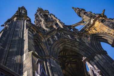 İskoç yazar Sir Walter Scott 'a ait Viktorya Dönemi Gotik anıtı olan Scott Anıtı açık mavi gökyüzüne karşı. İskoçya 'nın Edinburgh kentindeki Princes Street Gardens' da yer alan eser, dünyanın en büyük ikinci sanat eseridir.. 