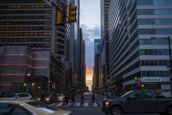 Philadelphia, PA/USA-Feb 29, 2020: A sunset glows over a busy intersection of Market and 15th streets, looking west from City Hall.