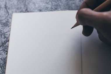 Not defteri, günlük ya da günlüğün beyaz boş sayfası ve metin ya da mesaj yazmak için el ve kopya alanı ile beton zemin üzerinde kalem olan fikirler. İş ve eğitim konseptinin minimalizm yaşam tarzı