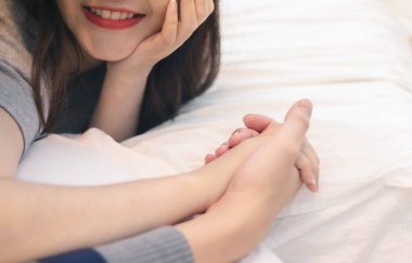 Çekici Asyalı genç bir gülümseme. Mutlu bir şekilde sarılıp, romantik bir anda el ele tutuşan çift. Sıcak kalp evliliği, sevgili bağı ve ilişki. Karı koca aşk fotoğrafı konseptinde.