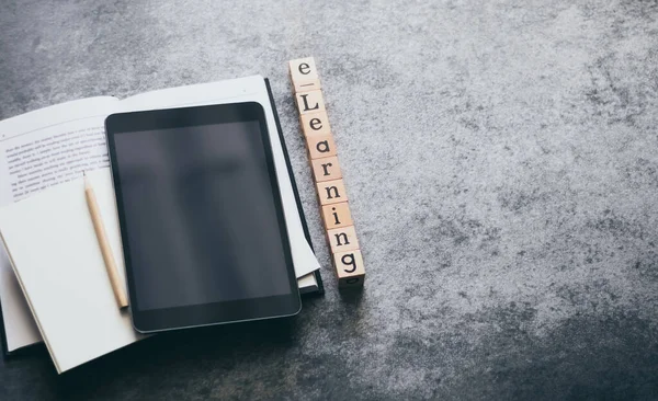 Tablet, ders kitabı ve kalemle ahşap küp e-öğrenme mektubu. İnternet eğitim kursu, uzaktan öğrenme ve internet bilgisi bas