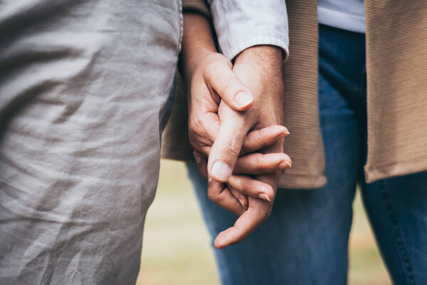 Lovely senior elderly smiling couple man and woman holding hand as promising of forever love or take care in romantic moment. Warm heart marriage and lover bonding and relationship. Love photo concep