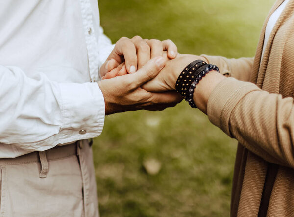 Lovely senior elderly smiling couple man and woman holding hands as promising of forever love or take care in romantic moment. Warm heart marriage & lover bonding and relationship. Love photo concept