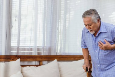 Emekli Asyalı yaşlı büyükbaba ya da erkek, evde kimse yokken kalp krizi ya da hastalıktan muzdarip. Sağlık sigortası ve sağlık sigortası konsepti