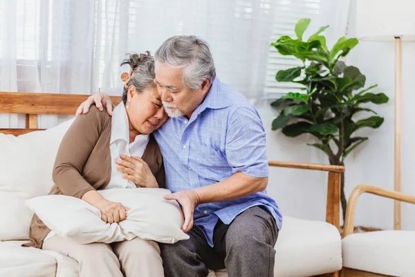 Retired Asian senior elderly wife pain from heart attack disease or illness with serious or worried husband take care at home. Medical emrgency treatment and health care insurance protection concept