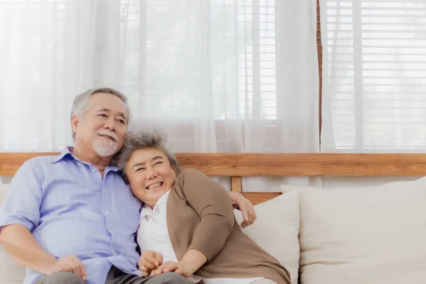 Mutlu Asyalı son sınıf çifti romantik bir anda evdeki kanepede birlikte kalıyorlar. Emekli, yaşlı, gülümseyen, büyük anne ve büyük baba aşığının kucaklaşması, sevgiyle kucaklaşması ve el ele tutuşması. Yaşlıların emeklilik hayatı