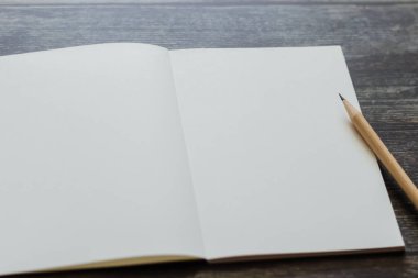 Beyaz boş bir defter ya da günlük ya da günlük, eski tahta masaya veya arka planda kopya alanı olan masa üzerine kalem ve mesaj yazmak için. Hala yaşam tarzı fotoğraf konsepti.