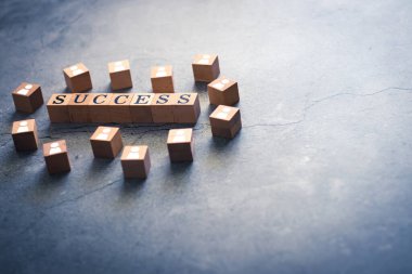 Başarı sözcüğünün tahta küpü & kopyalama alanı olan insanlar simgesi. Beyin yıkama, takım çalışması, ortaklık işbirliği ve işbirliği kavramları. İş hedefine ulaşmak için motivasyon fikirleri.