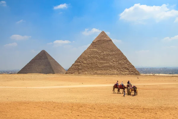 Carruaje de caballos con turistas frente a la Pirámide de Khufu y la Pirámide de Khafre en Egipto — Foto de Stock