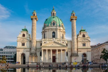 İnsanlar, Avusturya 'nın başkenti Viyana' daki Karlsplatz 'daki Karlskirche Katedrali veya St. Charles Kilisesi' nin önündeki güzel bir Eylül gününün tadını çıkarıyorlar.